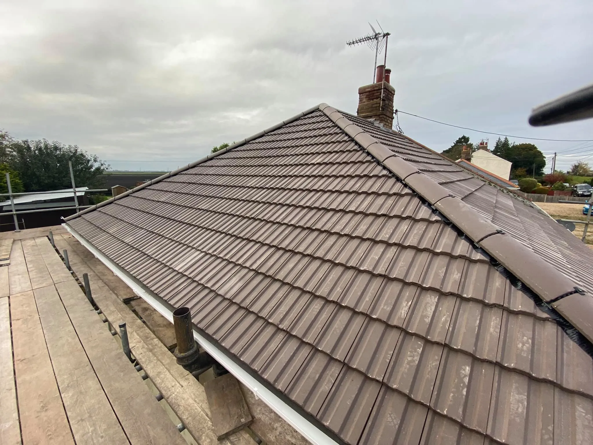 Concrete tiled hipped roof with new ridge tiles and guttering